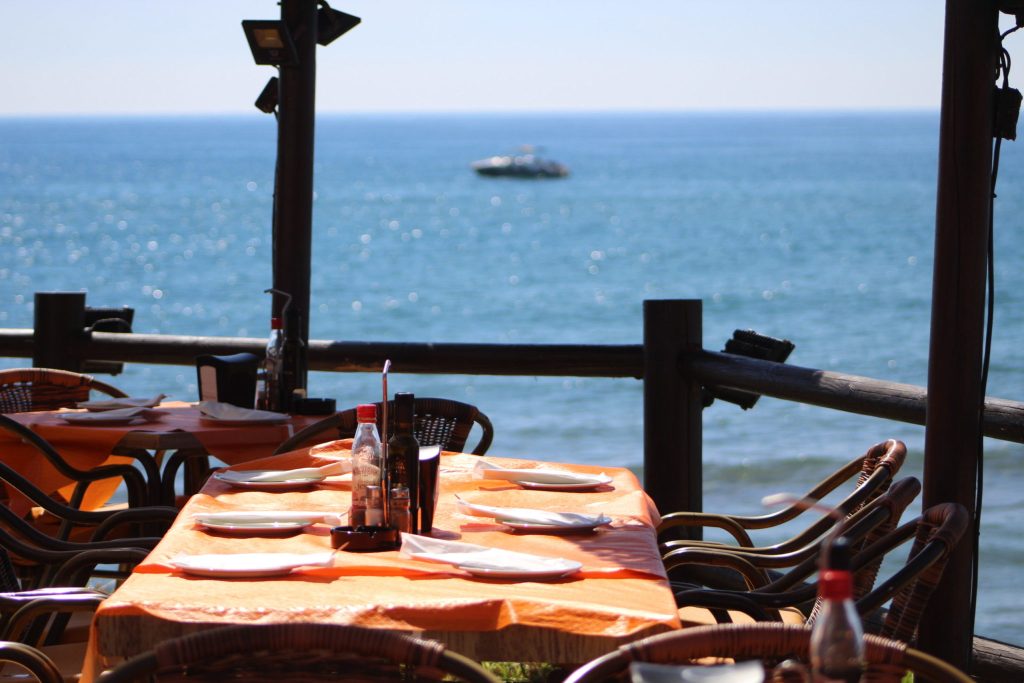 Terraza del Chiringuito Los Tonys con mesas listas para los comensales y vistas al mar Mediterráneo.