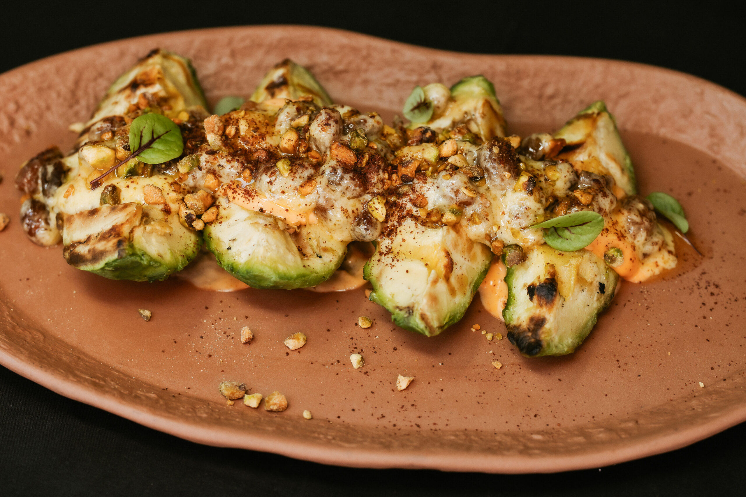 Grilled avocado with nuts, raisins and mango